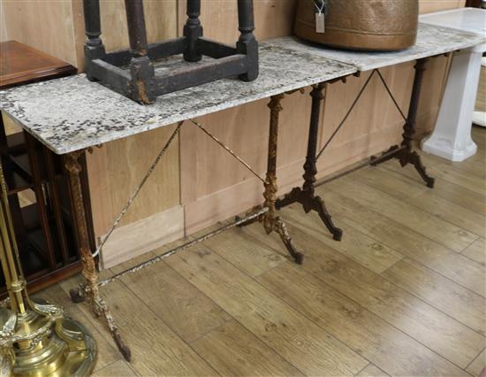 A pair of Victorian cast iron marble top garden tables W.104.5cm and 97.5cm